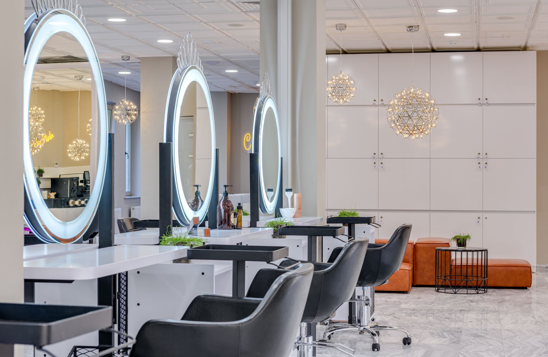 Salon Klara Interieur in Graz mit Designer-Sesseln und Rundspiegeln